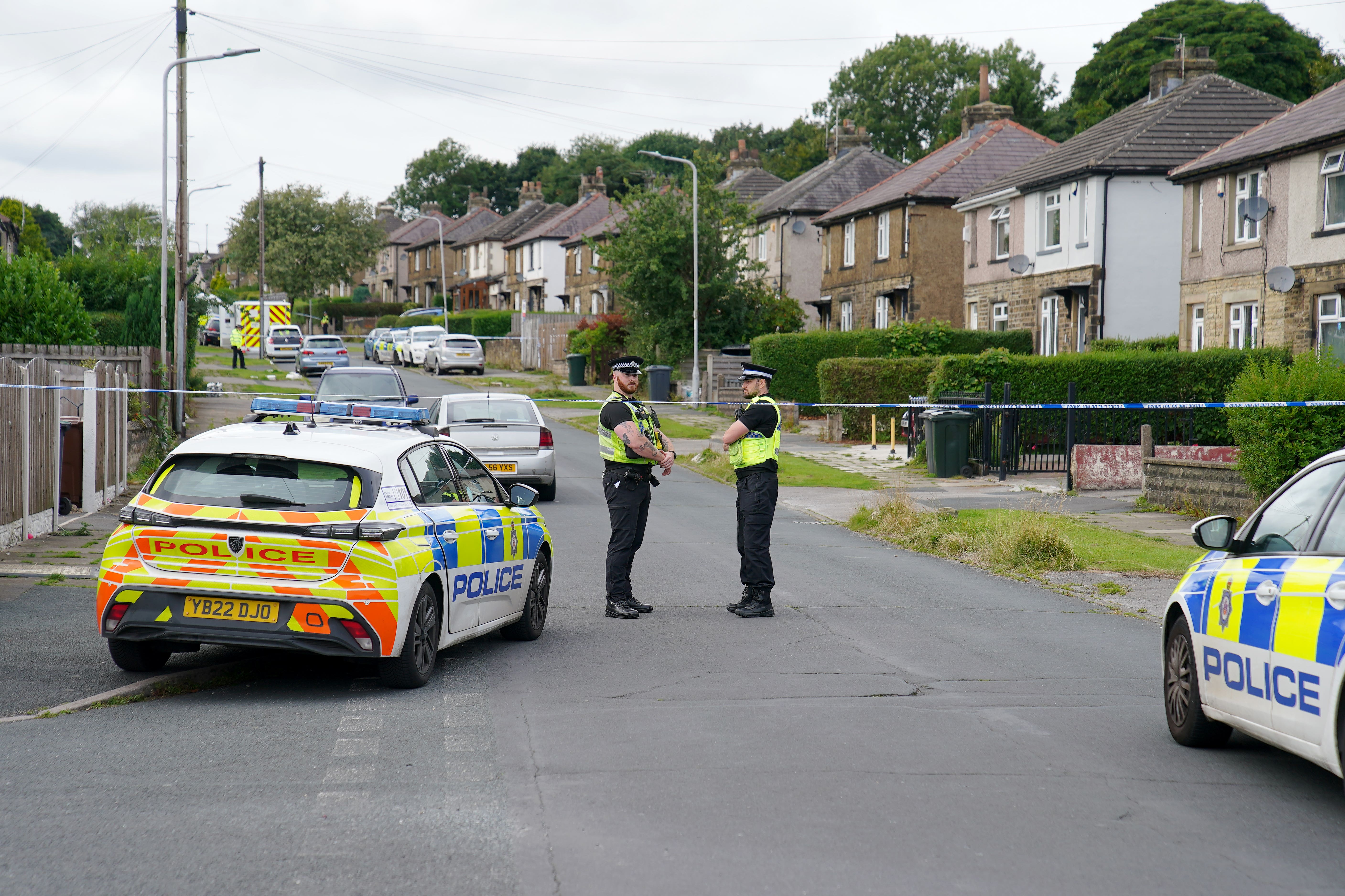 Emergency services in Westbury Road, Bradford, following the house fire (PA)