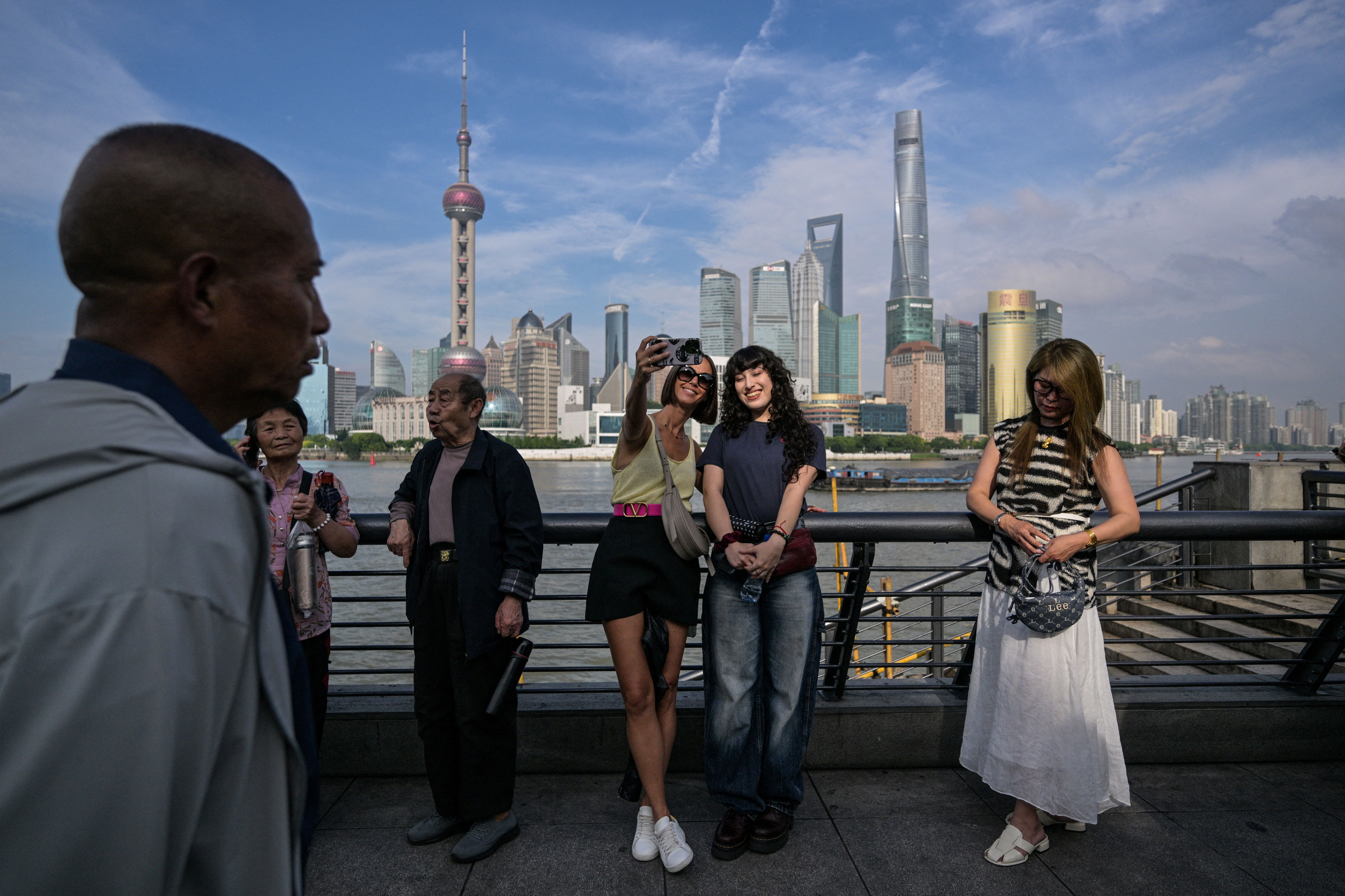 Os turistas pegaram uma selfie na margem do rio Huangpu em Xangai