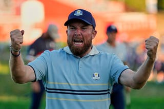 Europe's Shane Lowry celebrates after a birdie by Rory McIlroy on the 17th hole