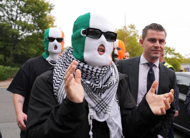 <p>Liam Óg Ó hAnnaidh, centre, outside the Woolwich Crown Court on Friday</p>
