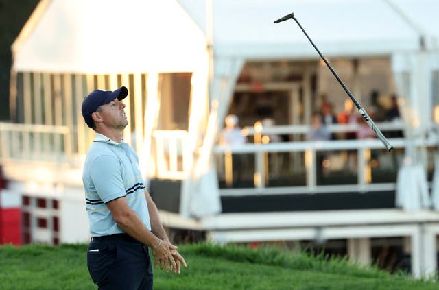 <p>Rory McIlroy throws his club after missing the final putt on day one</p>