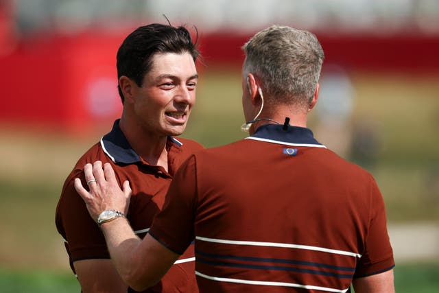 <p>Viktor Hovland of Team Europe talks with captain Luke Donald</p>