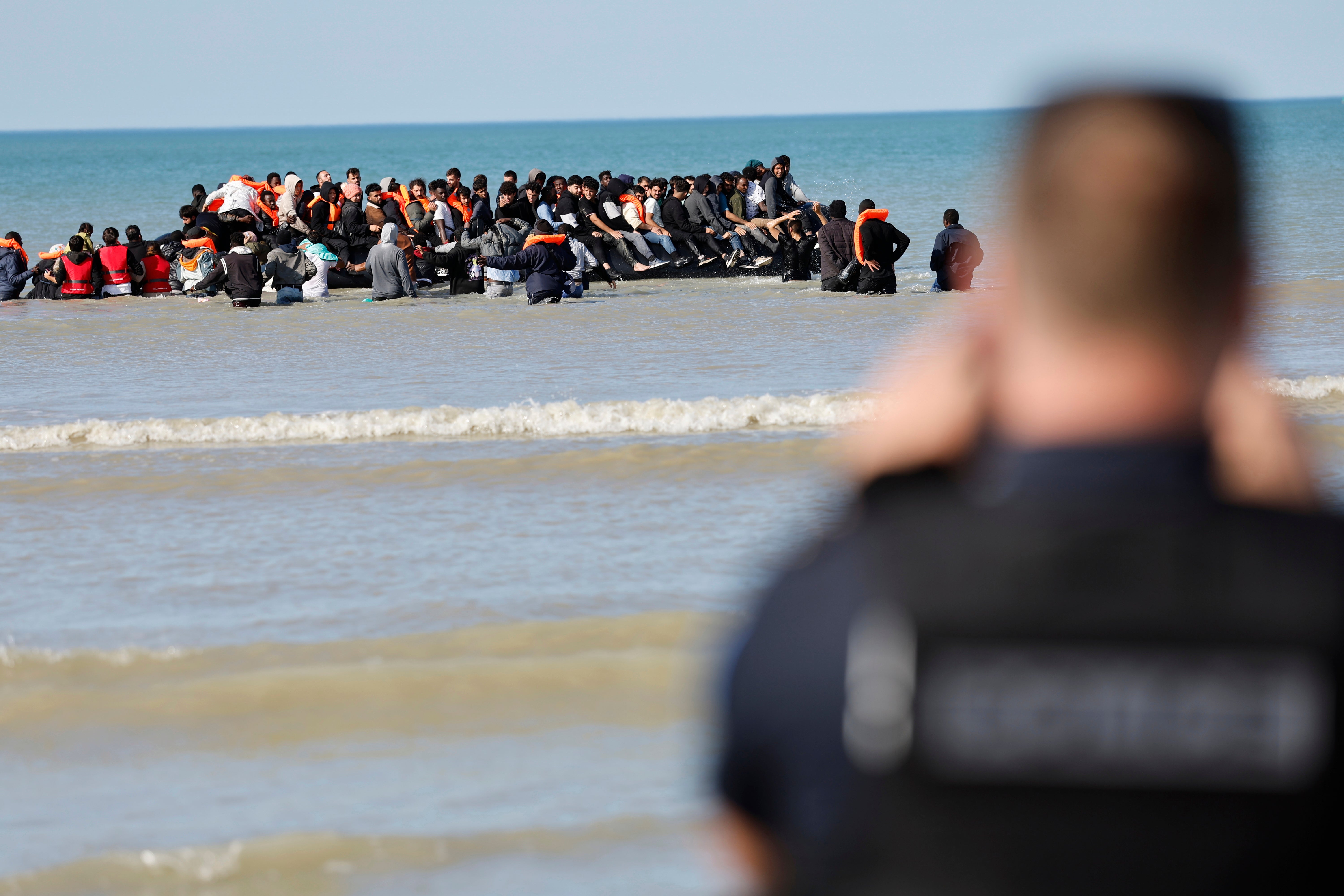 <p>French police officers take photos of migrants as they board a small boat to reach Britain, in Gravelines, northern France, France, Friday, Sept. 19, 2025. (AP Photo/Jean-Francois Badias)</p>
