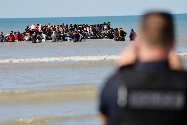 <p>French police officers take photos of migrants as they board a small boat to reach Britain, in Gravelines, northern France, France, Friday, Sept. 19, 2025. (AP Photo/Jean-Francois Badias)</p>