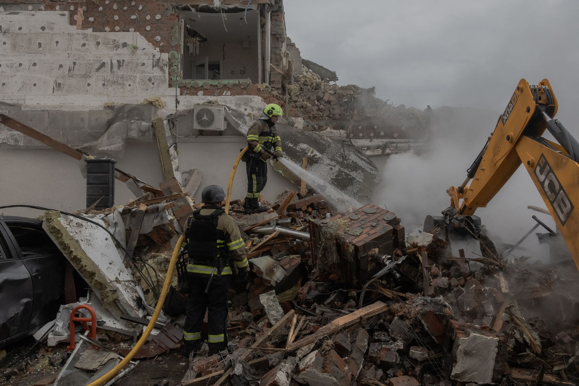 Ukrainian rescuers work at the site of heavily damaged residential buildings