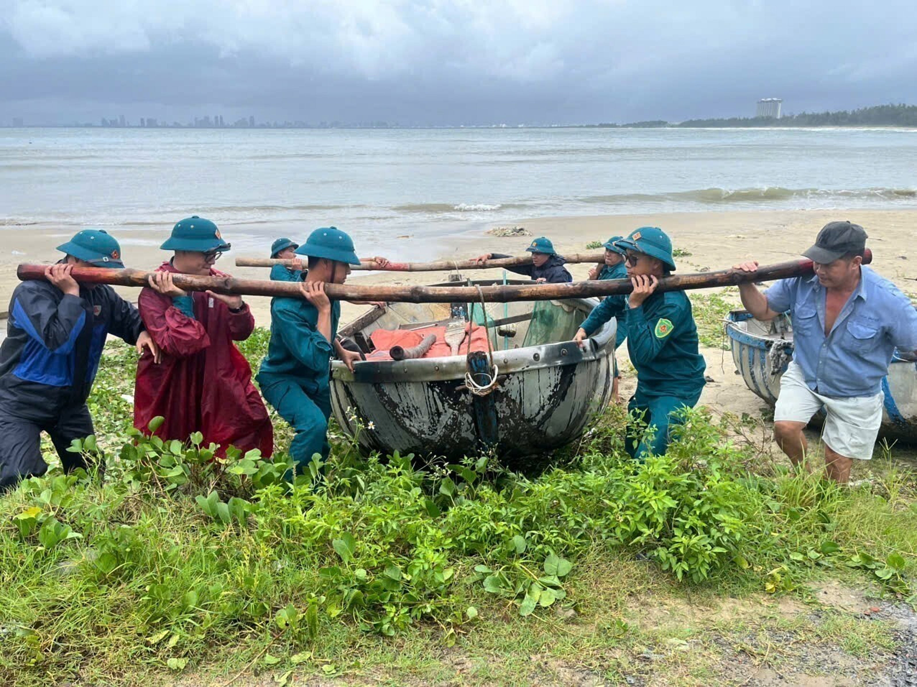 People move a fishing boat from the beach ahead of Typhoon Bualoi in Danang, Vietnam Sunday, 28 September 2025