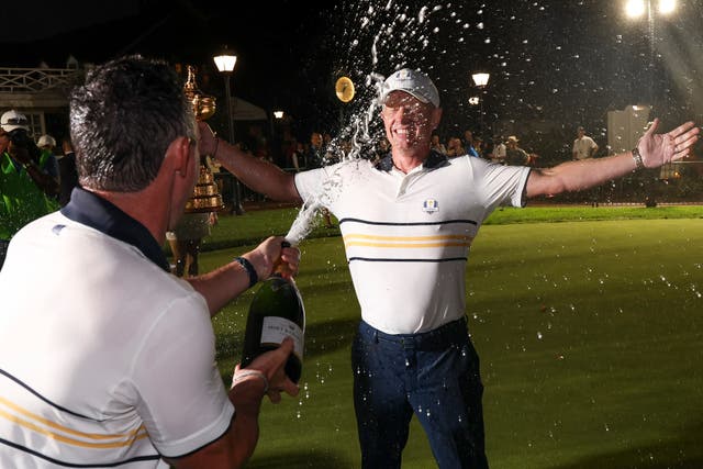 <p>Captain Luke Donald (R) of Team Europe holds the Ryder Cup trophy as he is doused with champagne by Rory McIlroy after Team Europe defeated Team United States 15-13 during the Sunday singles matches of the 2025 Ryder Cup at Black Course at Bethpage State Park Golf Course on September 28, 2025 in Farmingdale, New York. (Photo by Andrew Redington/Getty Images)</p>
