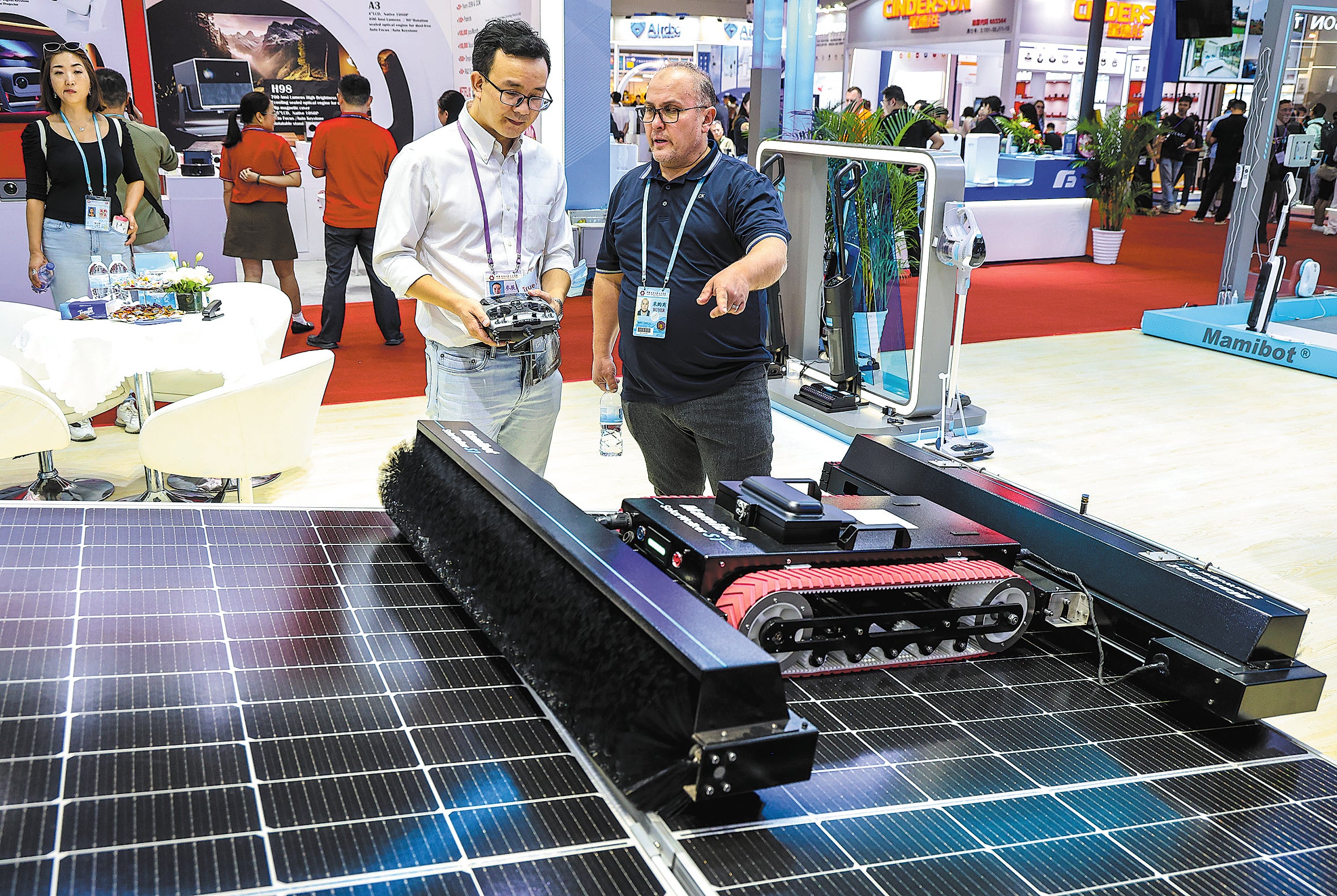 A visitor enquires about a robot that cleans photovoltaic panels during the 136th Canton Fair in Guangzhou, Guangdong province