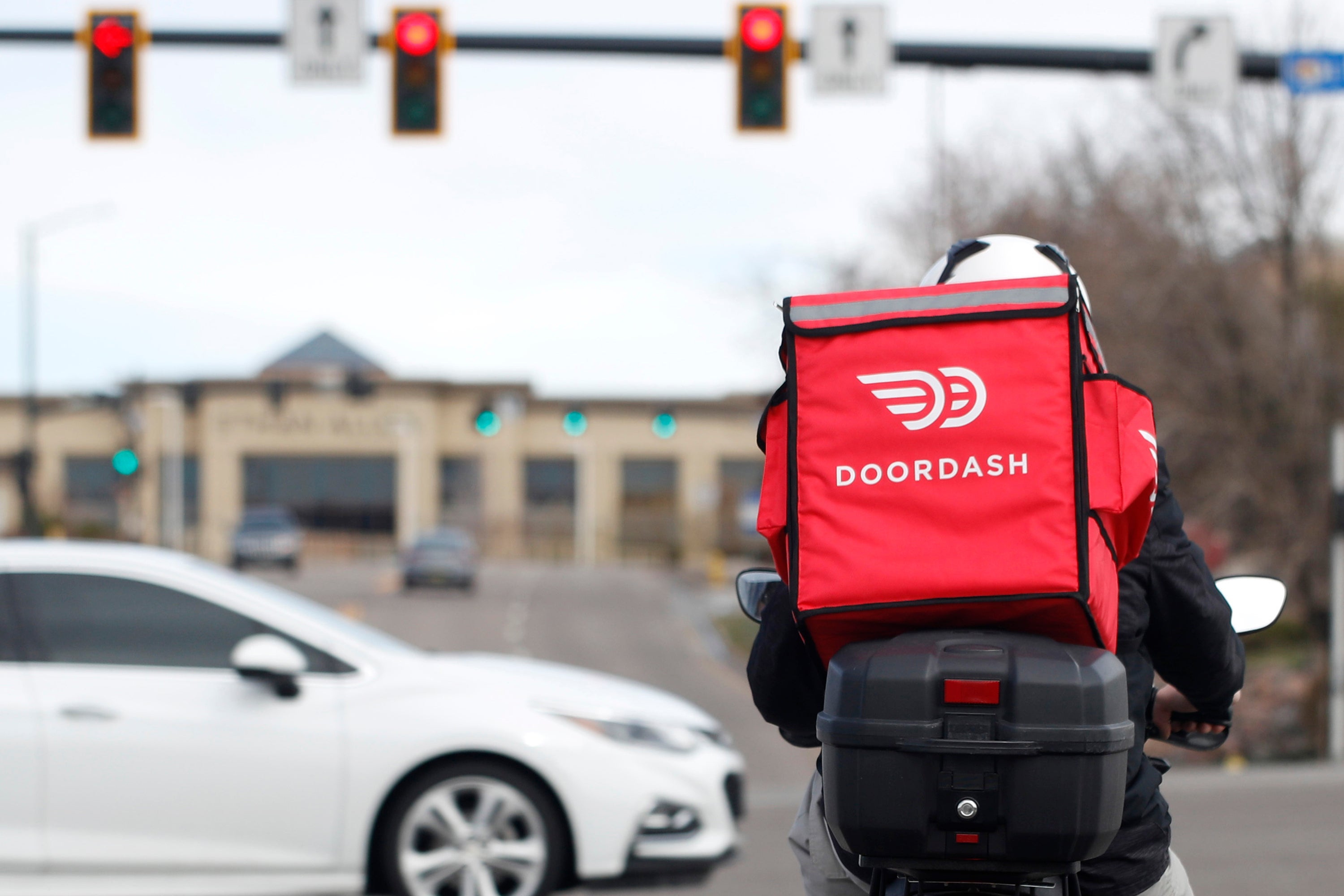 File. A food delivery rider waits for the traffic light to change