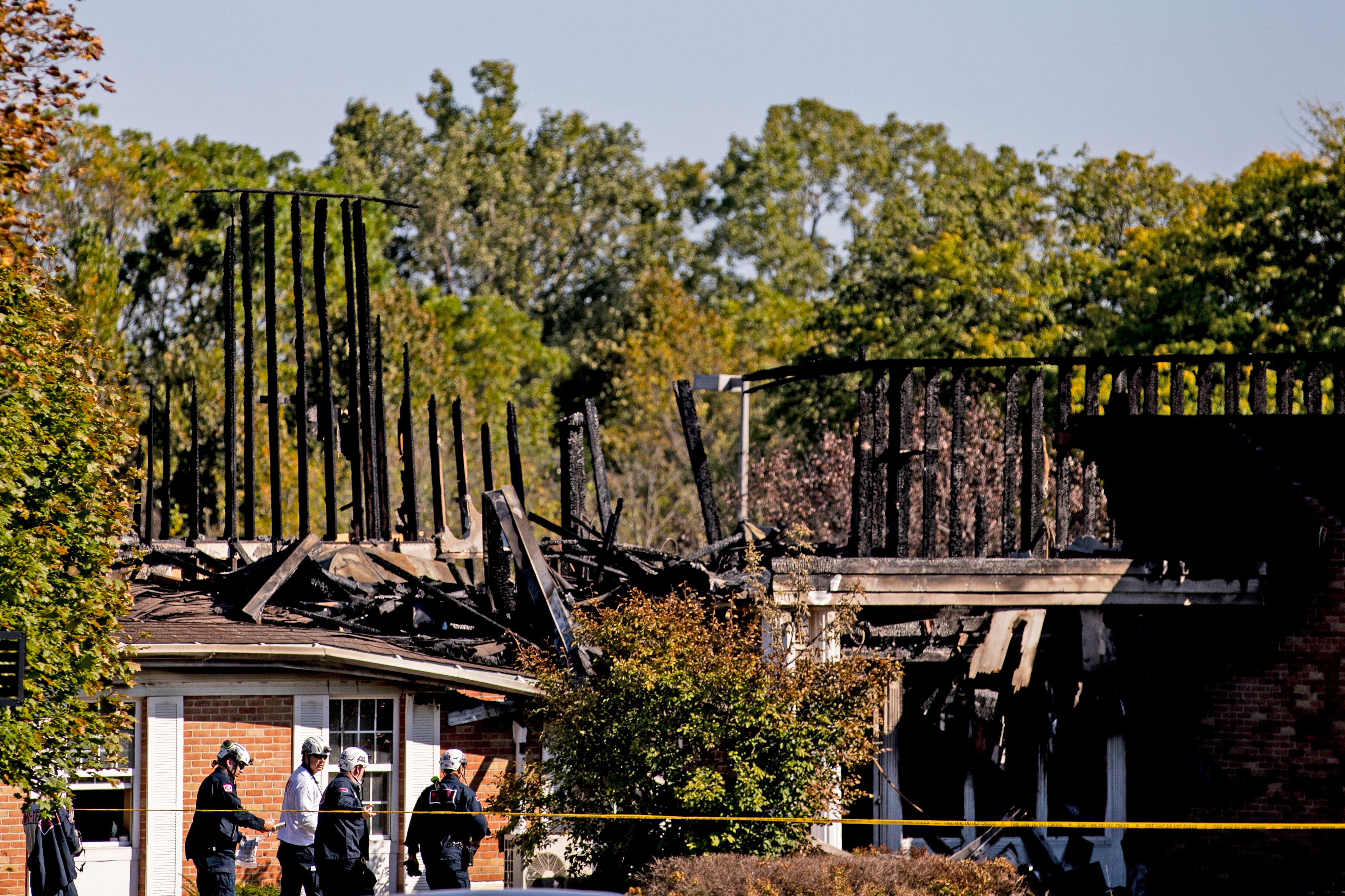 Police officers survey the remains of the Church of Jesus Christ of Latter-day Saints on Monday
