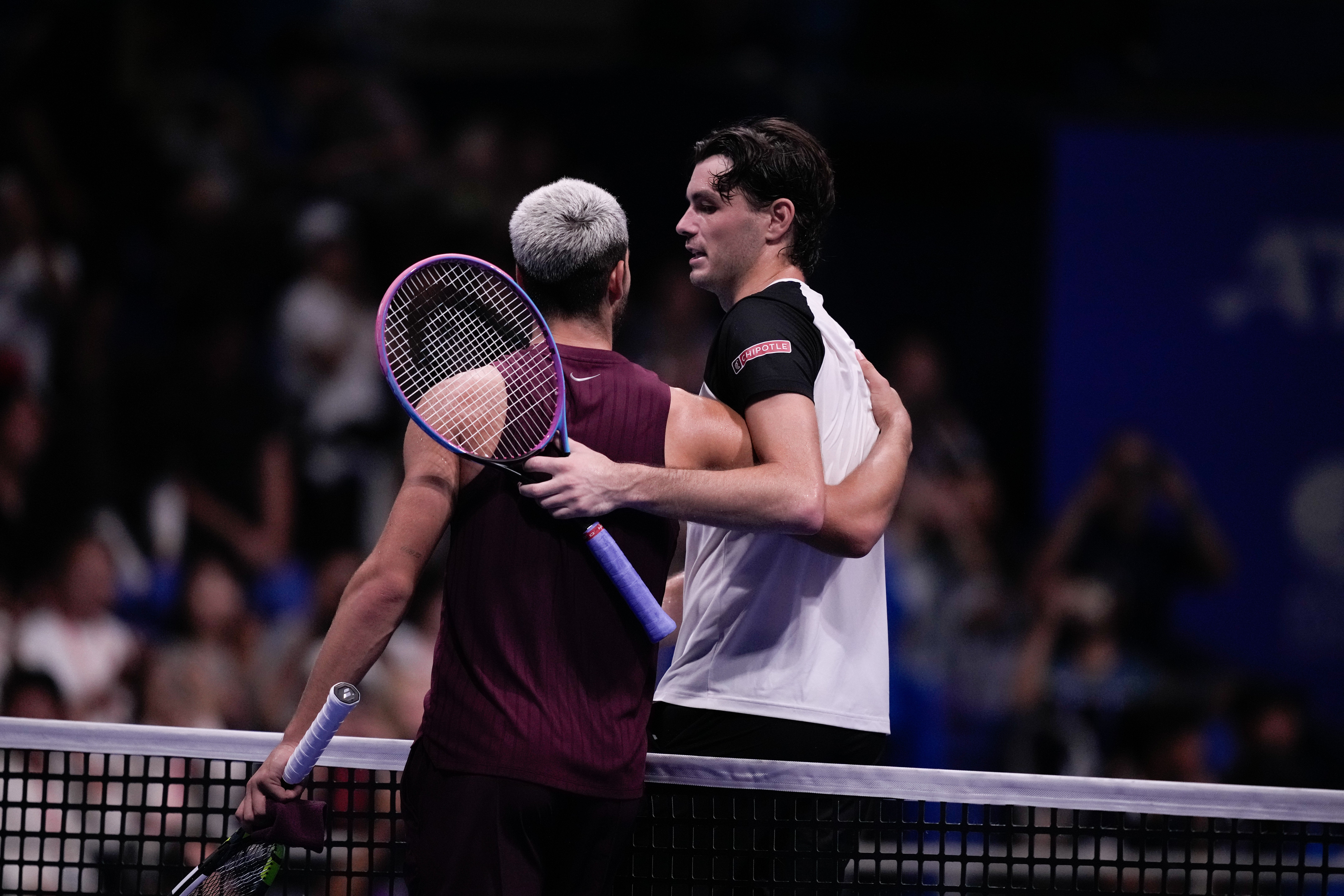 Carlos Alcaraz, izquierda, y Taylor Fritz se abrazan en la red (Louise Delmotte/AP)