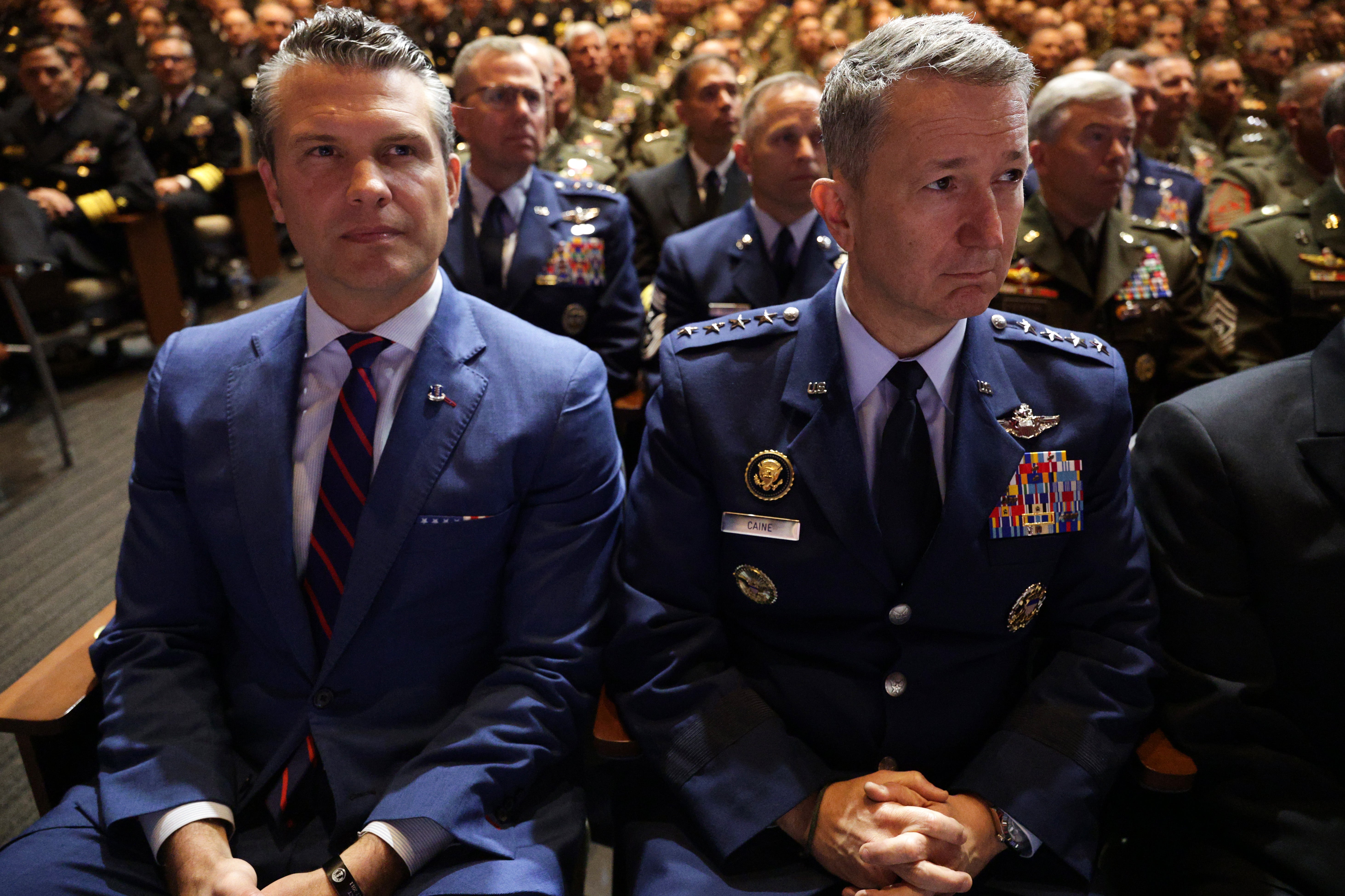 Secretary of Defense Pete Hegseth (L) and Chairman of the Joint Chiefs of Staff Air Force Gen. Dan Caine listen as U.S. President Donald Trump speaks to senior military members at Marine Corps Base Quantico on September 30, 2025