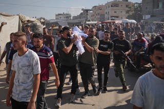 Os palestinos carregam o corpo de uma pessoa morta no ataque israelense em Deir al-Balah, no vale de Gaza