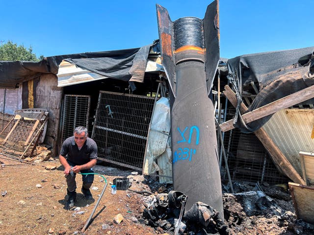 <p>A man poses next to apparent remains of a ballistic missile following today's missile attack by Iran on Israel, in northern Israel</p>