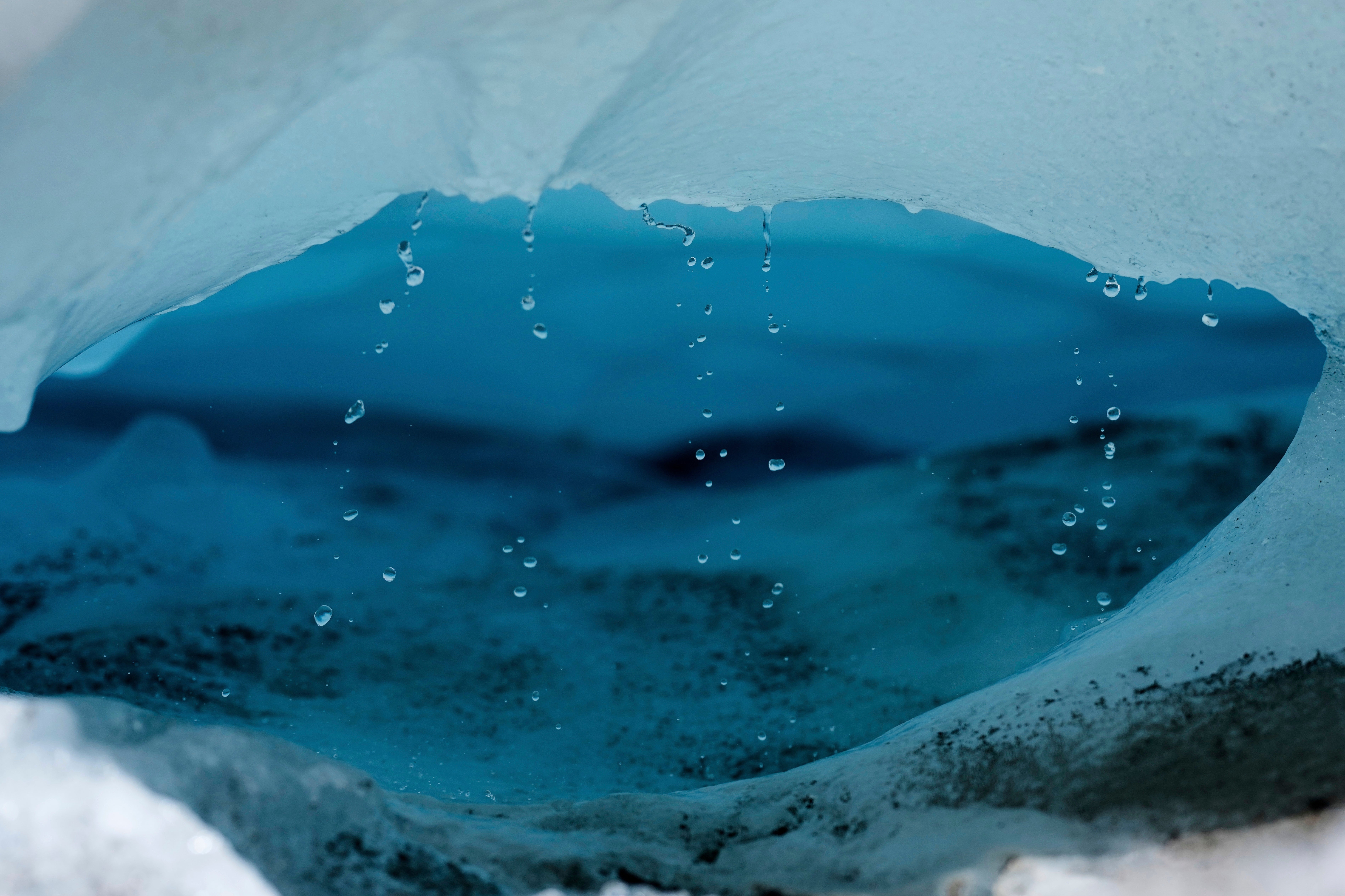 <p>Water drips from a melting chunk of ice that originated from the Rhone Glacier near Goms, Switzerland</p>