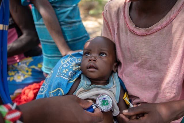 <p>Meldah (7 mths) is held by her brother Kenya (8) while being checked for malnutrition by a doctor in Turkana, Kenya</p>