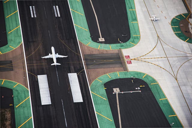 <p>A passenger jet landing on the runway and a small private plane on a neighboring taxi-way at  San Diego International Airport</p>