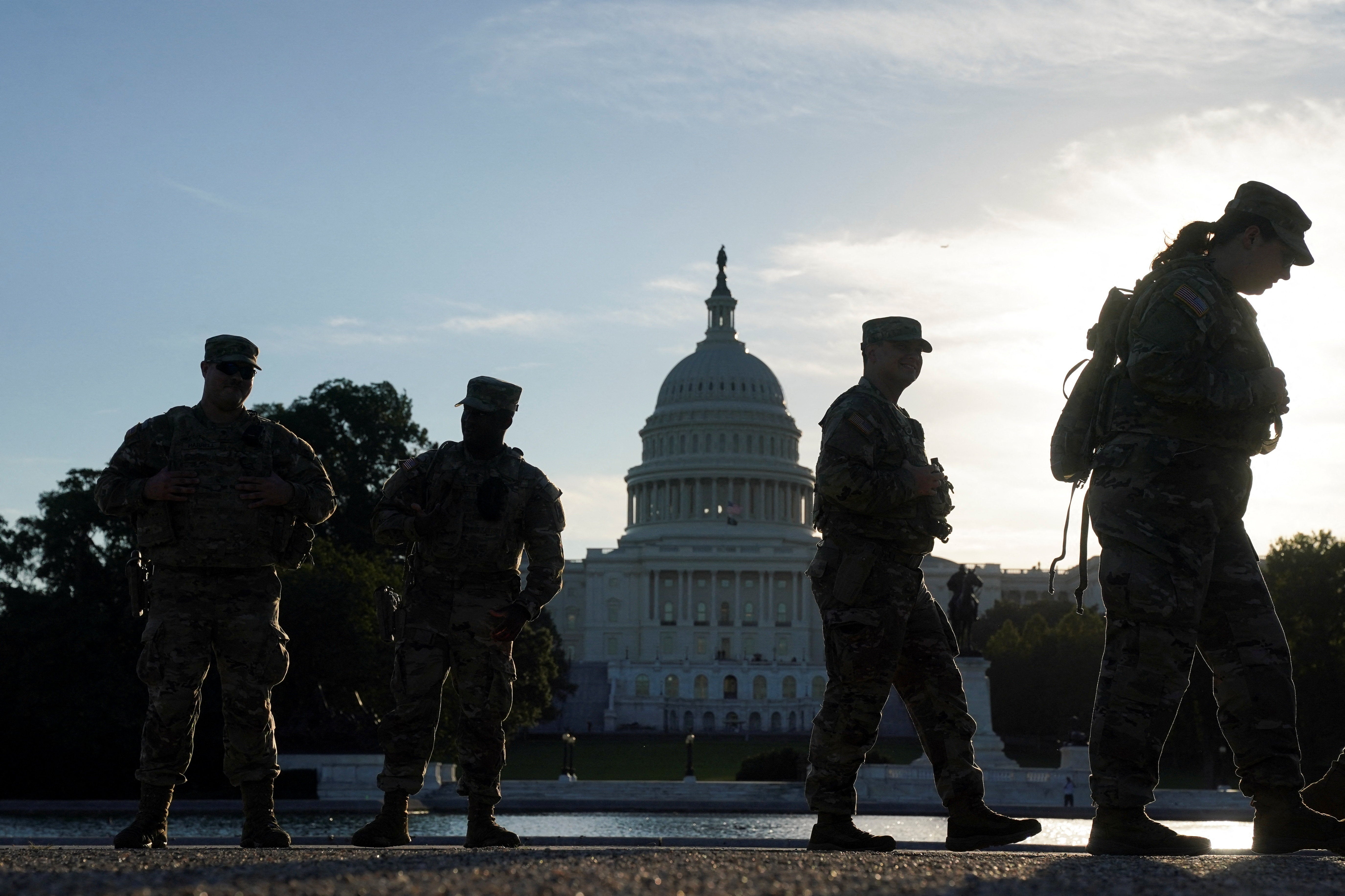 Members of the National Guard walk, with the U.S. Capitol in the background, during the first day of a partial government shutdown in Washington, D.C., U.S., October 1, 2025. REUTERS/Nathan Howard
