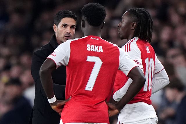 Arsenal manager Mikel Arteta speaks with substitutes Bukayo Saka and Eberechi Eze (Bradley Collyer/PA)