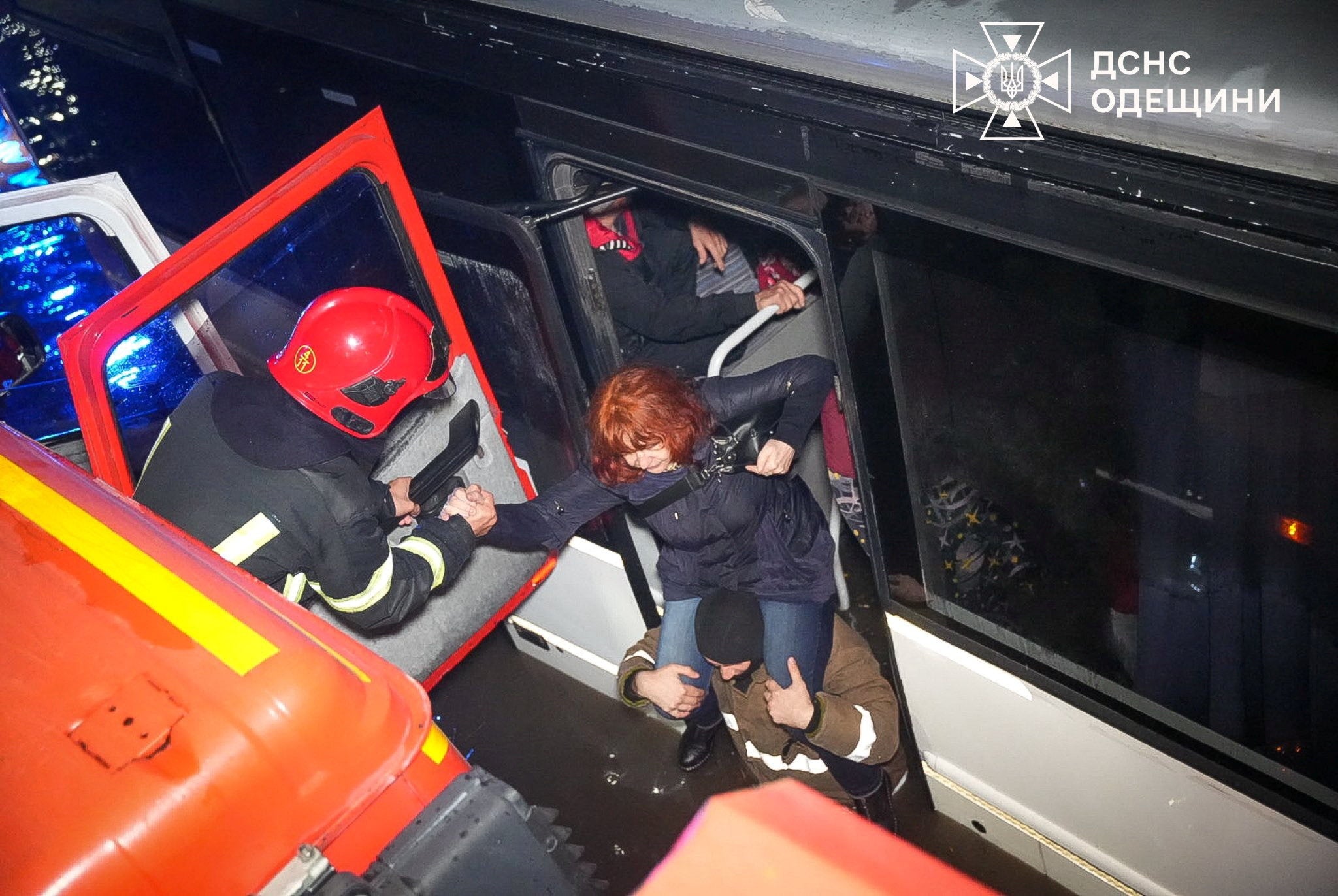 Rescuers evacuate bus passengers on a flooded street, following unprecedented rainfall in Odesa