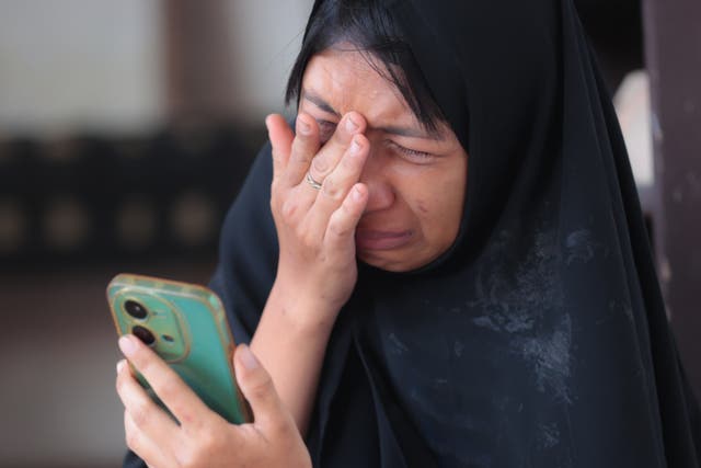 <p>Una mujer llora mientras los equipos de rescate buscan víctimas atrapadas bajo los escombros de una escuela derrumbada en Sidoarjo, Java Oriental, Indonesia</p>