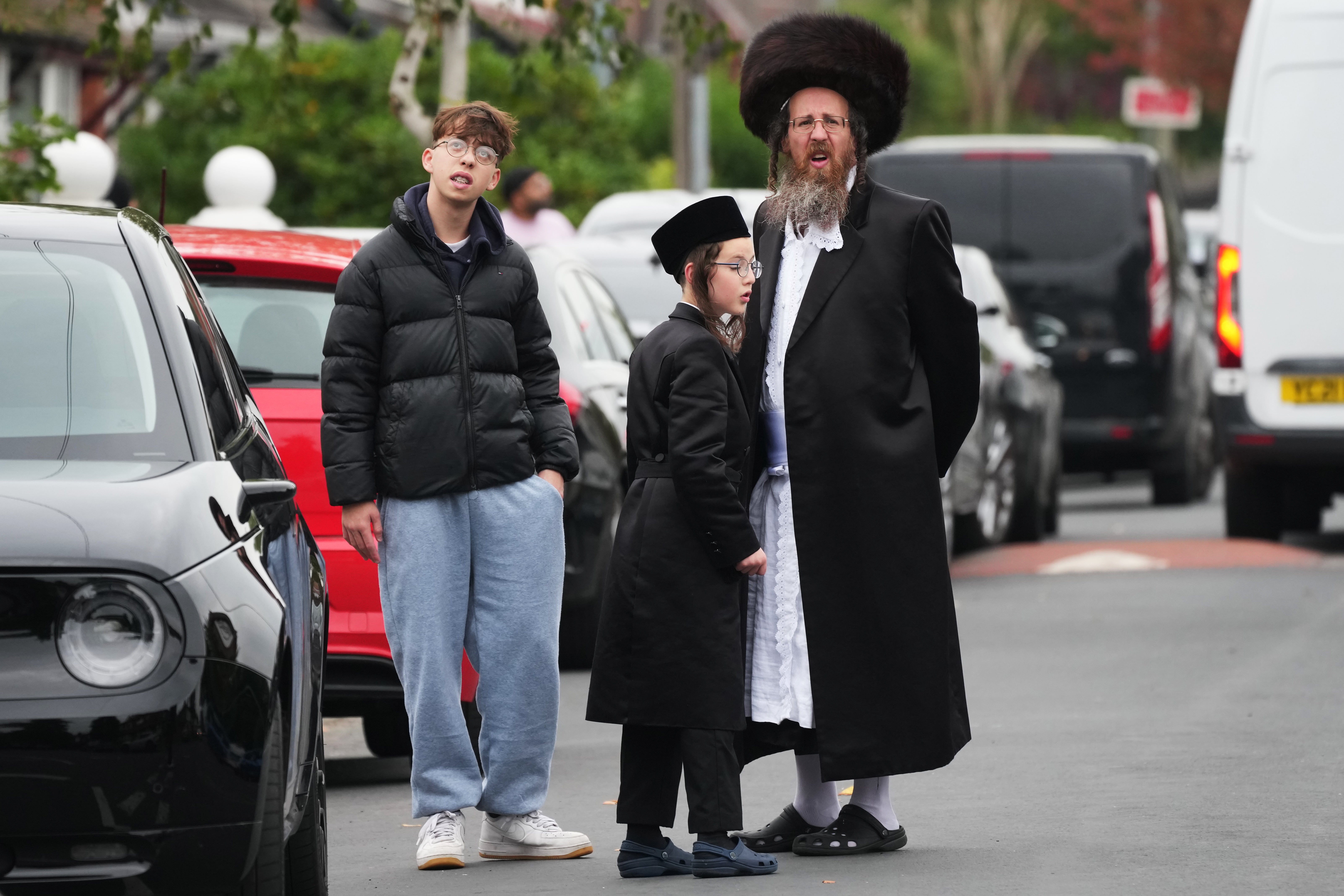 Members of the public look on as police, emergency responders and congregants gather near the Heaton Park Hebrew Congregation Synagogue