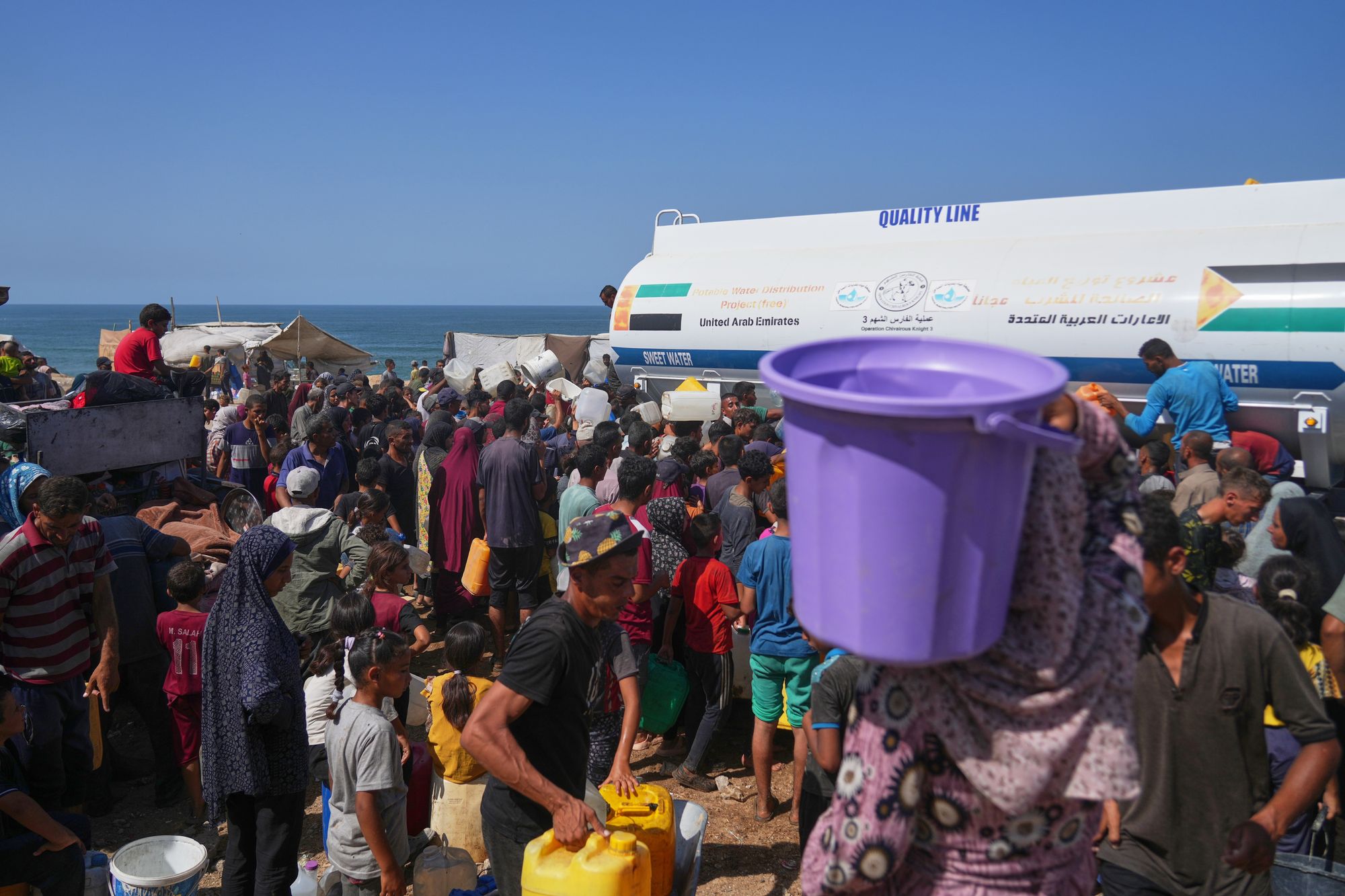 Poisened water and shattered grid: Gaza left in environmental freefall after war, report says Displaced Palestinians gather to collect water from a truck at a makeshift camp in Nuseirat, central Gaza Strip