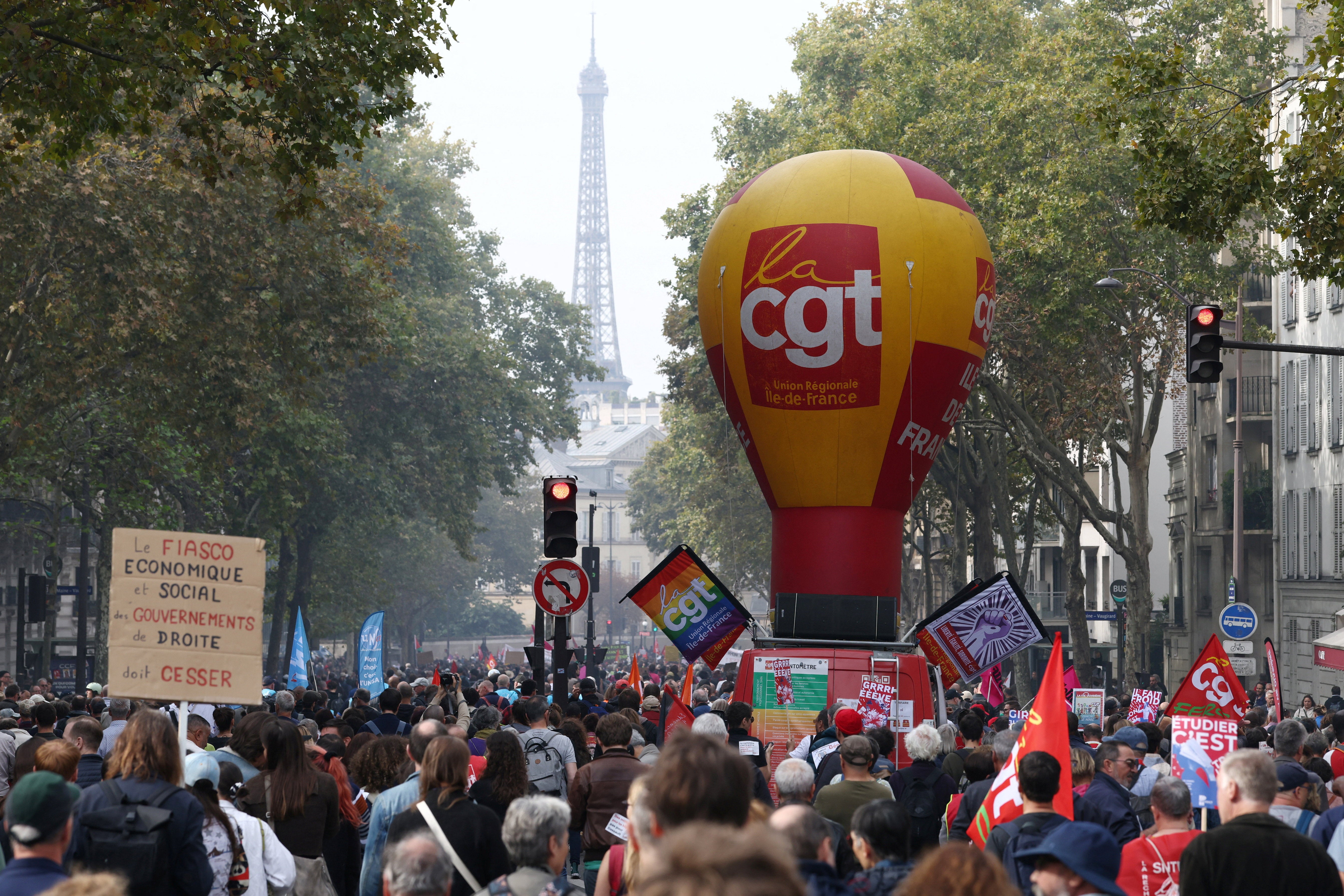 Protesters walk next to the CGT labour union balloon, with the Eiffel Tower in the background, during a demonstration in Paris as part of a day of nationwide strikes and protests against the government