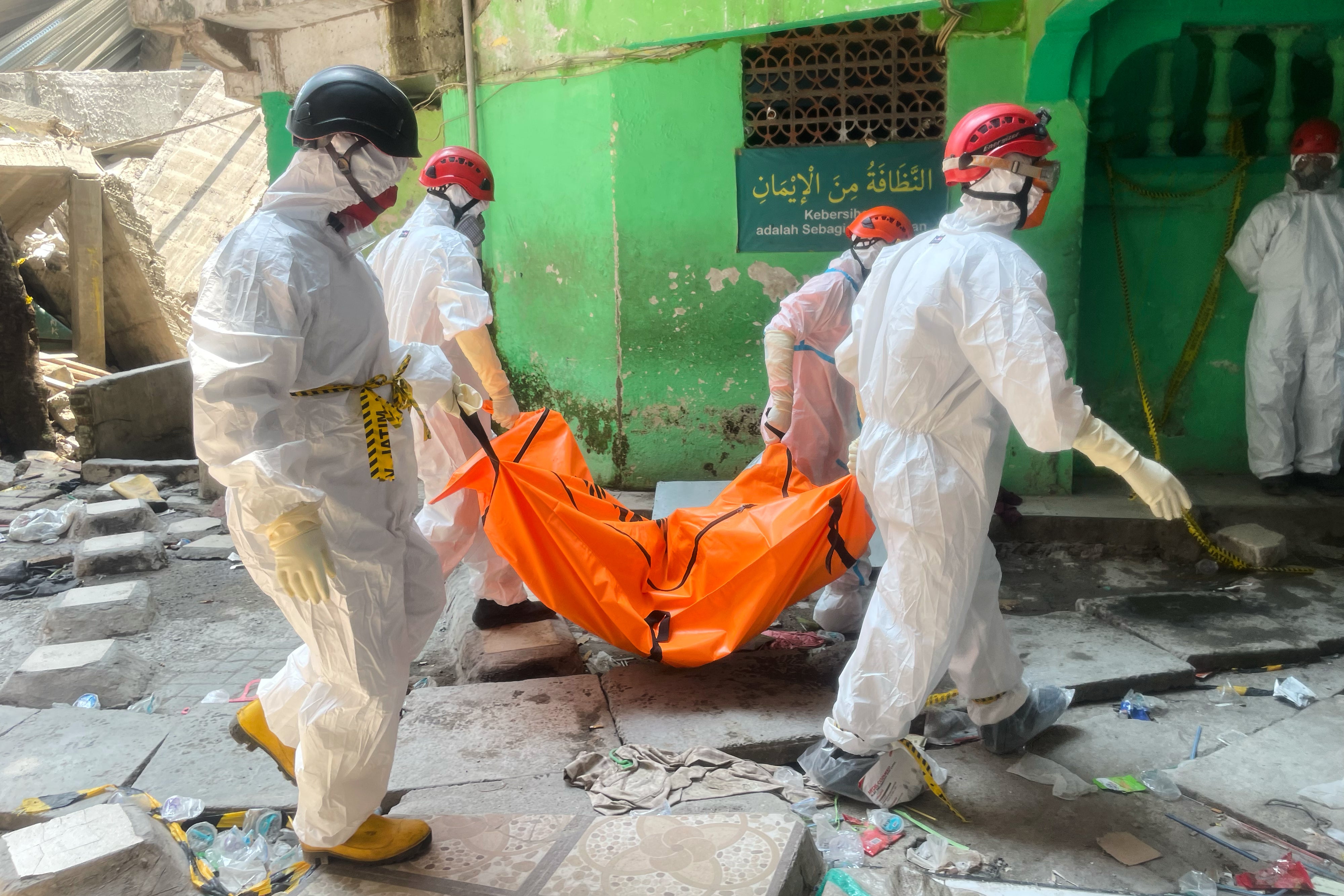 Rescuers remove a body bag from the scene in East Java province