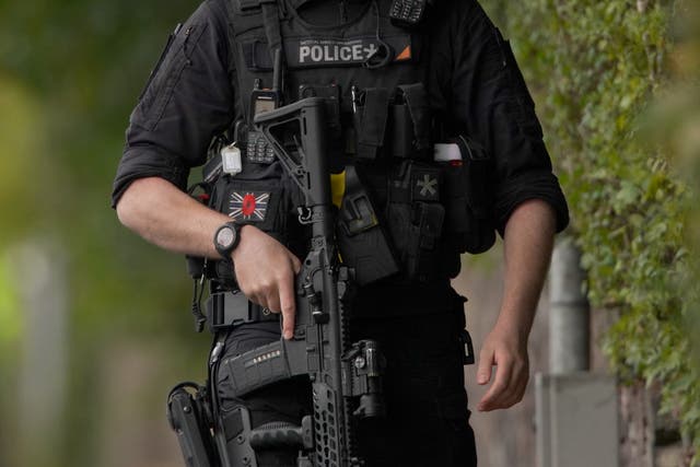 <p>An armed police officer patrols near the scene of a terror attack at a synagogue in Crumpsall, Manchester, yesterday</p>