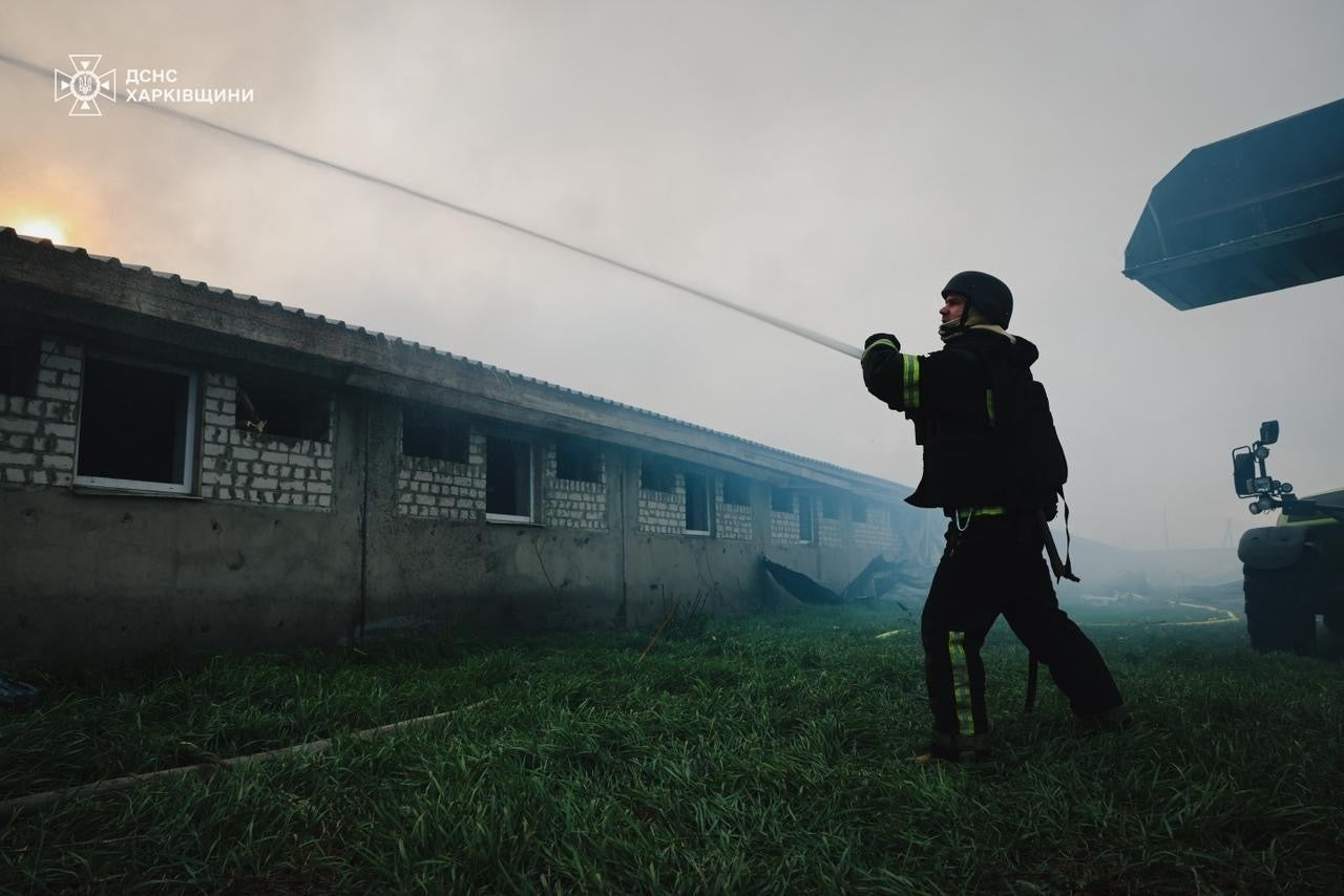 A rescuer works at the site of the pig farm on Friday