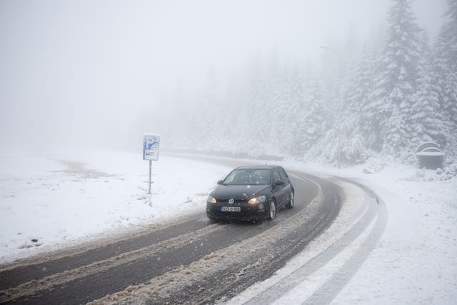 <p>A car drives along a road during an unexpected snowfall on mountain Jahorina near Sarajevo, Bosnia</p>