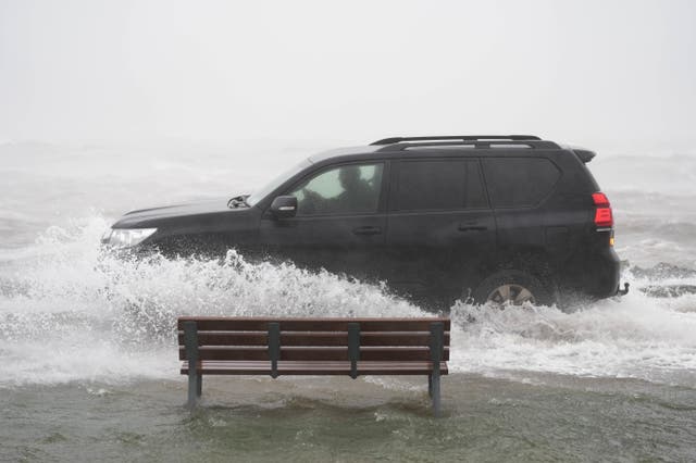 <p>A car drives through floodwater as Storm Amy sweeps across Ireland  </p>