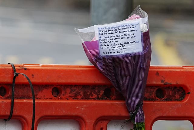 A message on a bunch of flowers left near Heaton Park Hebrew Congregation synagogue in Crumpsall, Manchester (Peter Byrne/PA)
