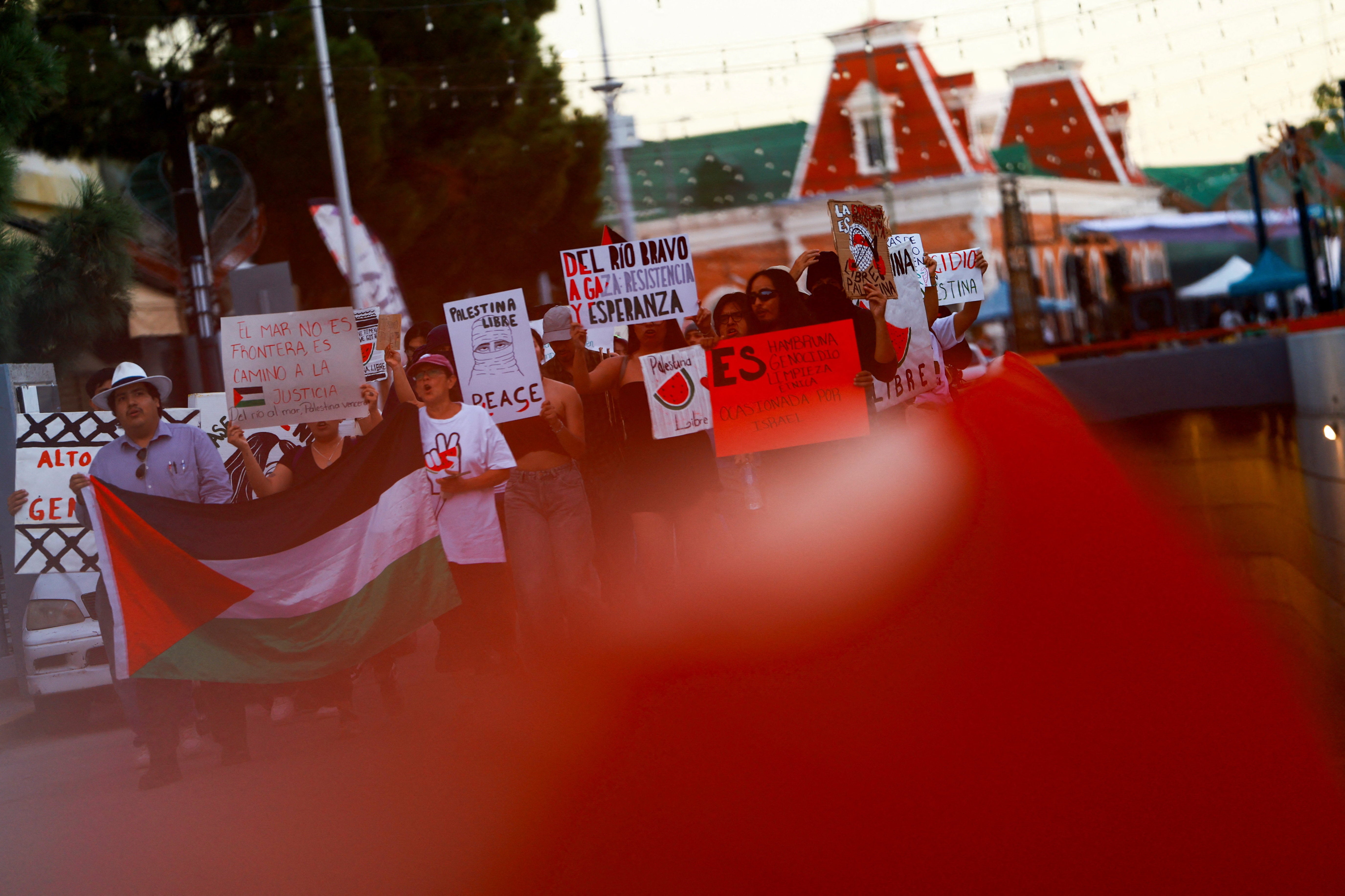 Pro-Palestinian demonstrators hold signs during a protest to condemn the Israeli forces' interception of some of the vessels of the Global Sumud Flotilla aiming to reach Gaza and break Israel's naval blockade, near the Paso del Norte International Bridge in Ciudad Juarez, Mexico