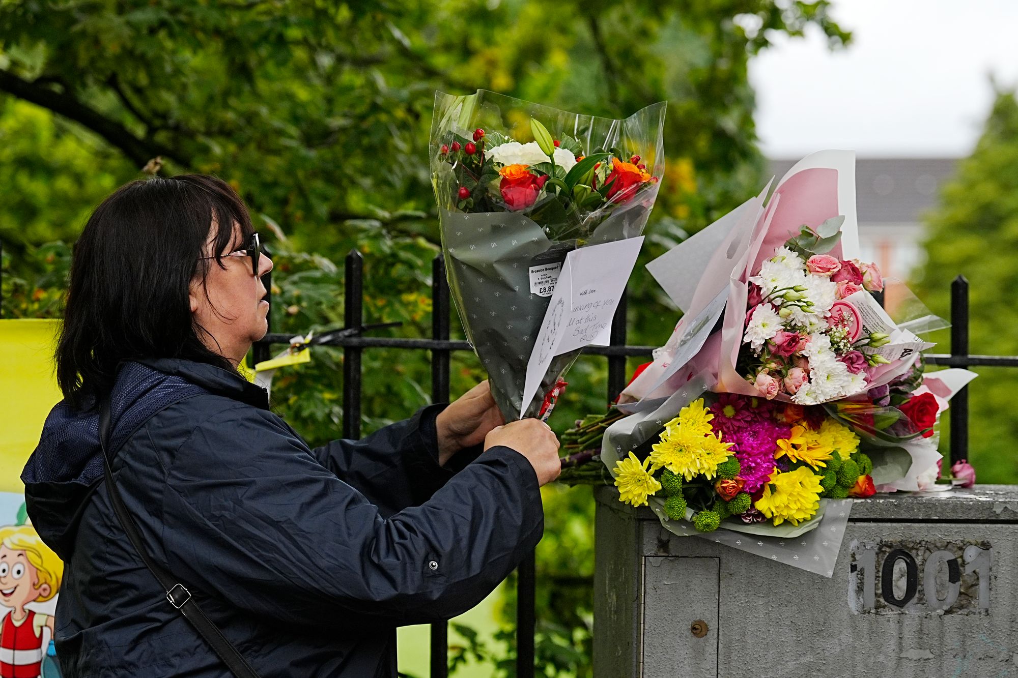 A woman places bunches of flowers and tribute messages at the Heaton Park Hebrew Congregation synagogue in Crumpsall, Manchester, where two people died in a terror attack on Thursday.