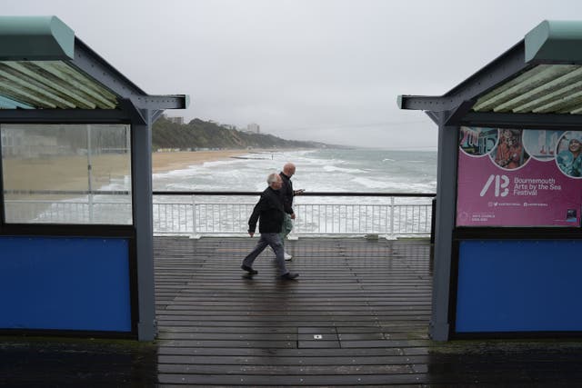 People walk along Bournemouth Pier in Dorset as high winds hit (Andrew Matthews/PA)