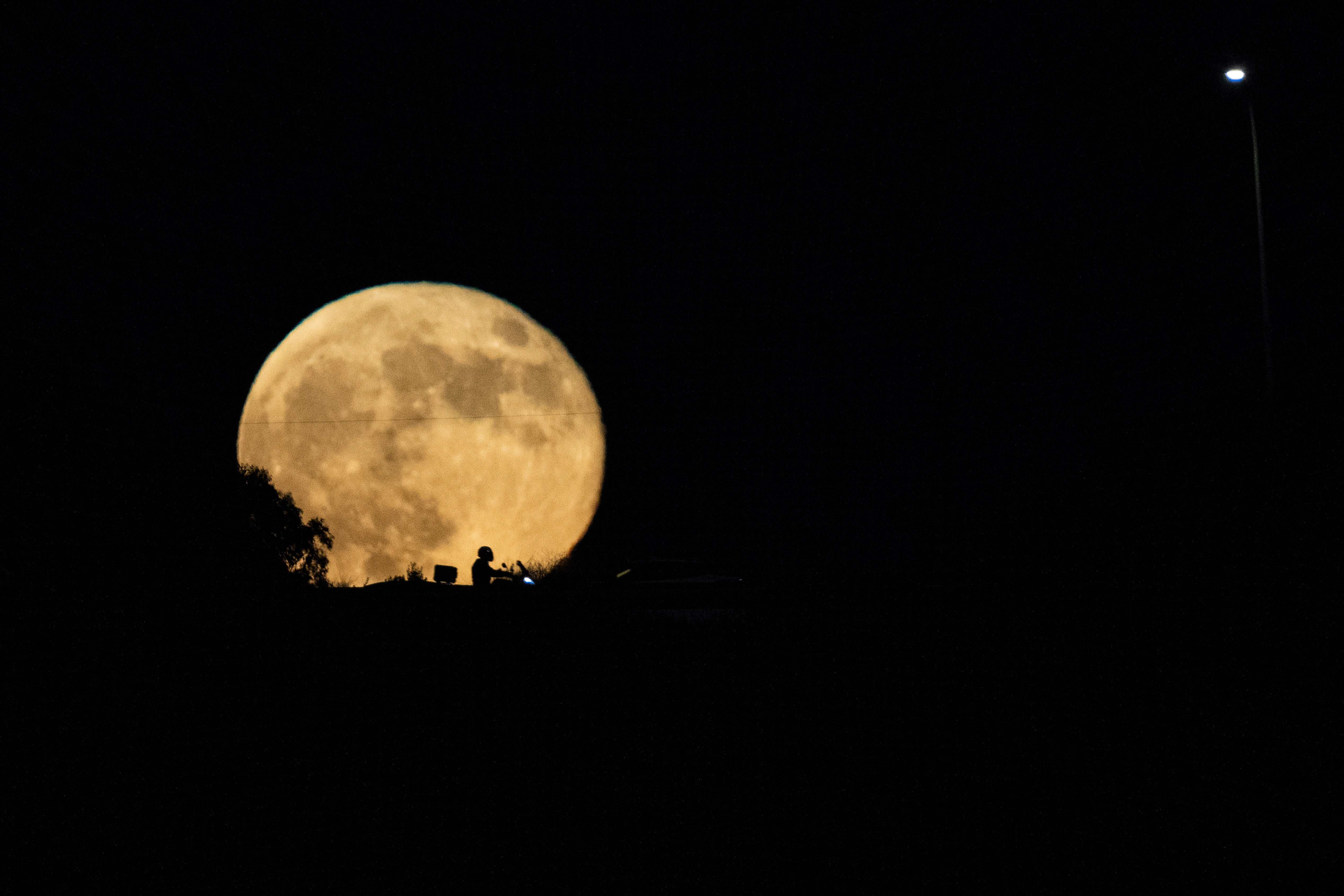The moon rises in the sky over a freeway as drivers pass between Haifa and Tel Aviv, Israel, Wednesday, Sept. 18, 2024