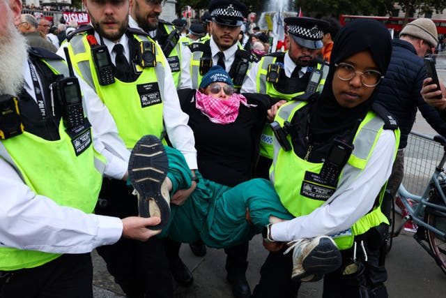 <p>Police officers detain a protester during a mass demonstration organised by Defend our Juries</p>