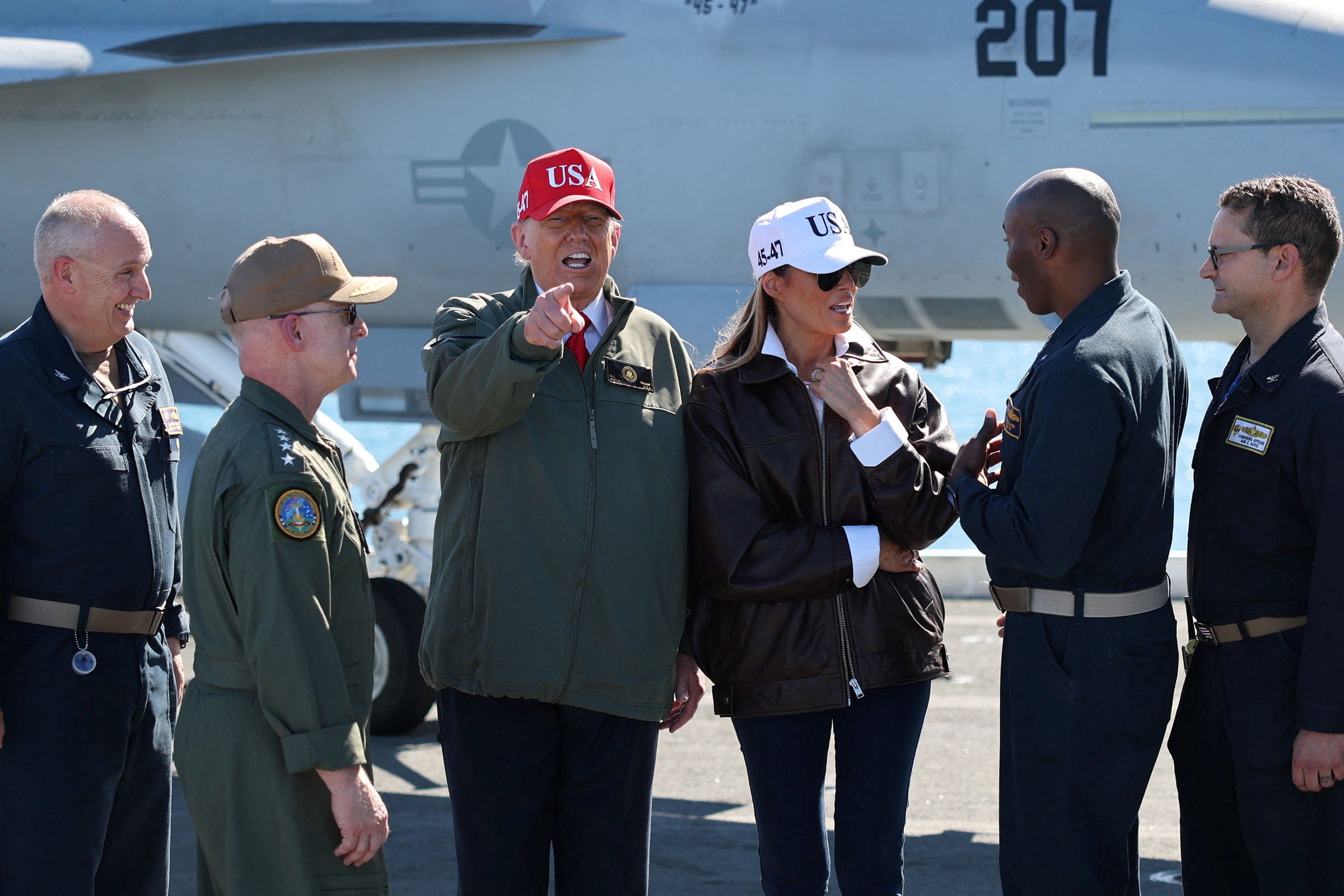Trump gestures aboard the aircraft carrier USS George H.W. Bush next to first lady Melania Trump, off the coast of Norfolk, Virginia