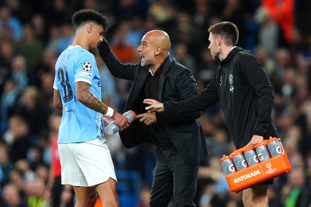 <p>Manchester City manager Pep Guardiola (centre) speaks with player Nico O'Reilly (left)</p>