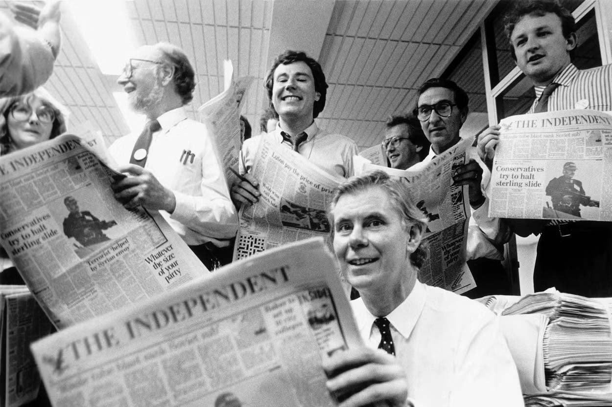 1986: Smith holding a copy of the first official Independent newspaper surrounded by editorial staff