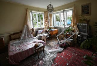 Shattered glass on the floor inside a room of a house damaged during a Russian drone and missile strike in the village of Lapaivka on the outskirts of Lviv