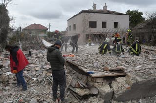 Rescuers search for victims in the debris of a destroyed house following a Russian rocket strike on the outskirts of Lviv