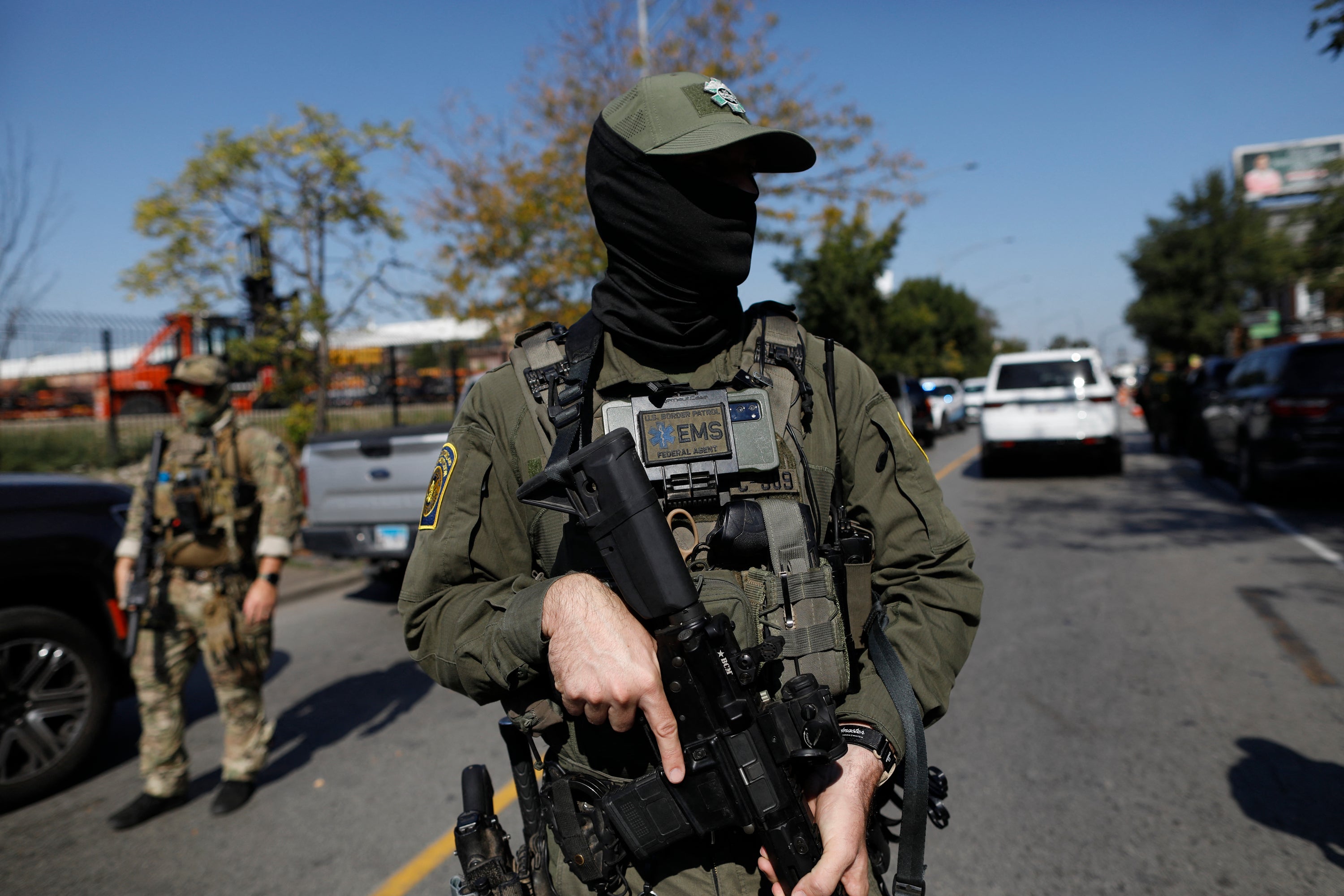 A masked U.S. Customs and Border Protection Border Patrol agent is seen as residents of Chicago's Brighton Park neighborhood confront law enforcement on Saturday