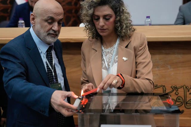 <p>Syrian election officials burn red wax to stamp a ballot box ahead of the parliamentary elections at Latakia’s Governor ballot station</p>
