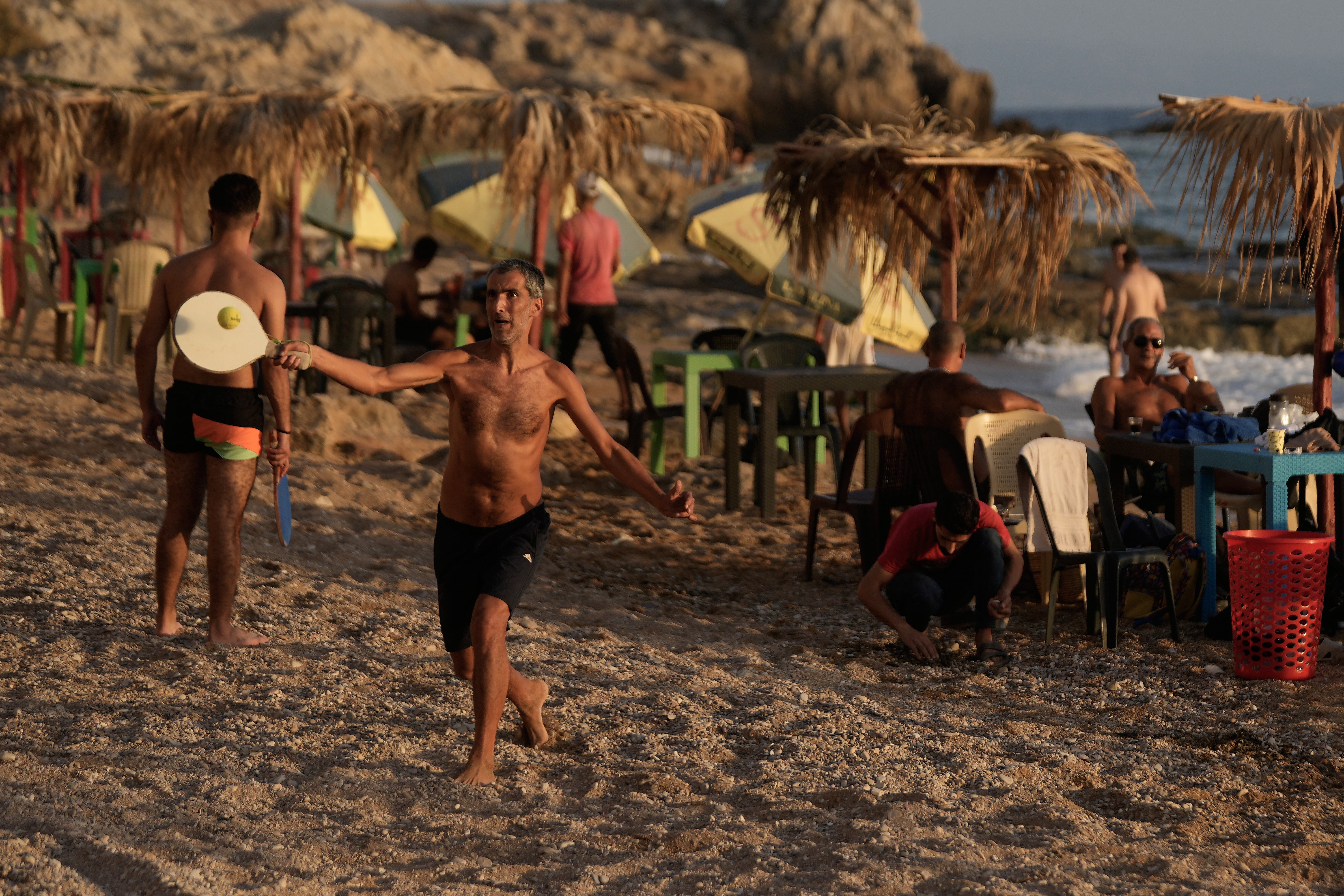 People play racketball at a public beach in Latakia, Syria