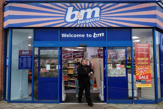 <p> Shoppers walk by the B&M store in London</p>