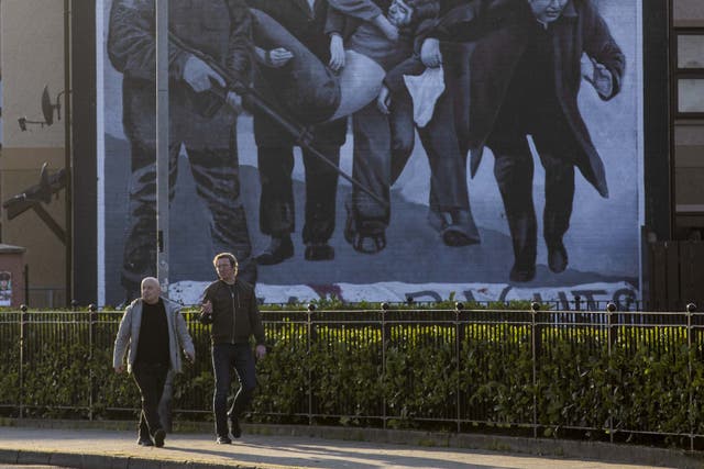 People walking past the Bloody Sunday Commemoration mural in Derry, Northern Ireland (Liam McBurney/PA)