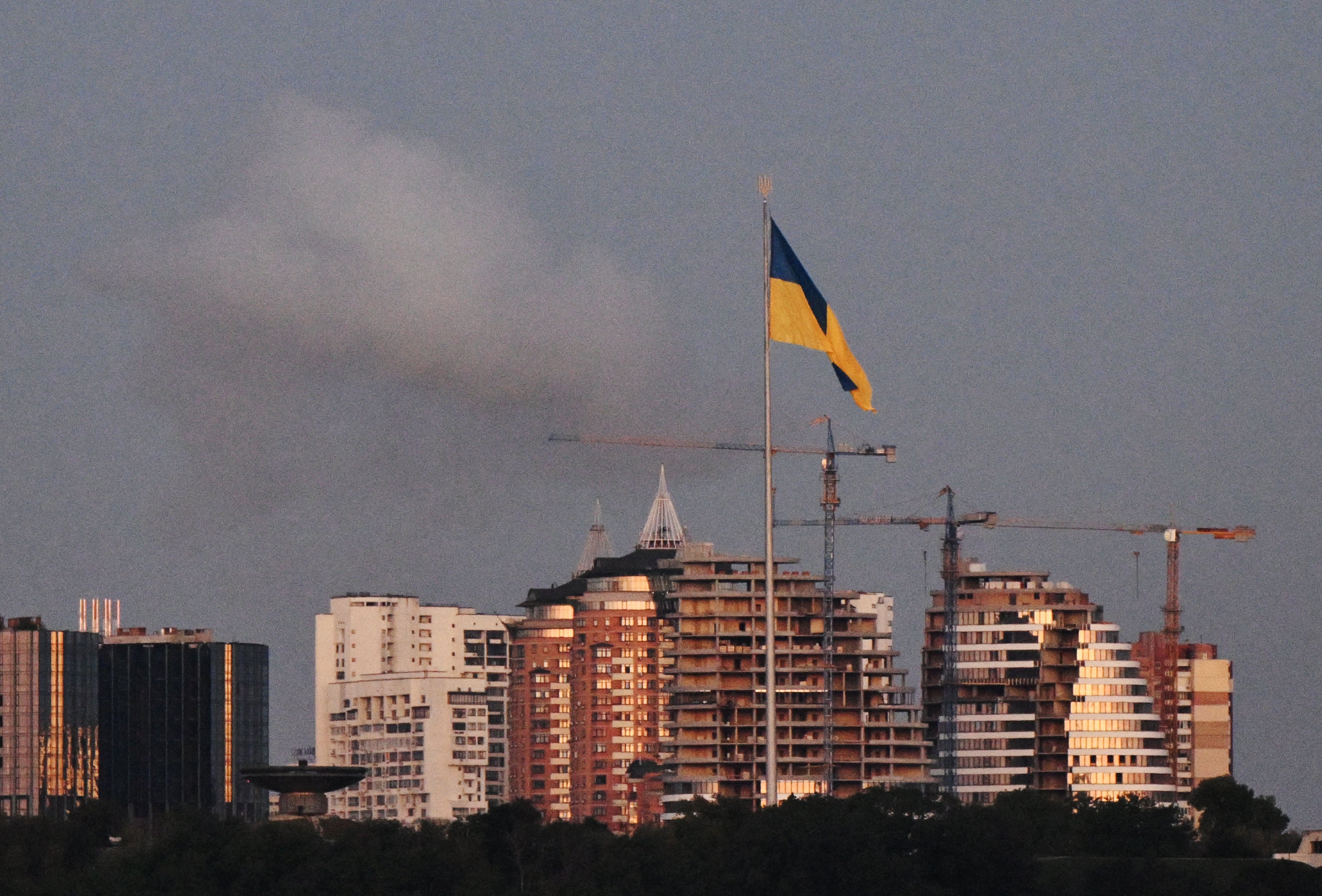 Uma fumaça nas costas de uma grande bandeira ucraniana sobre um drone russo de grande escala em Kiev e uma enorme bandeira ucraniana